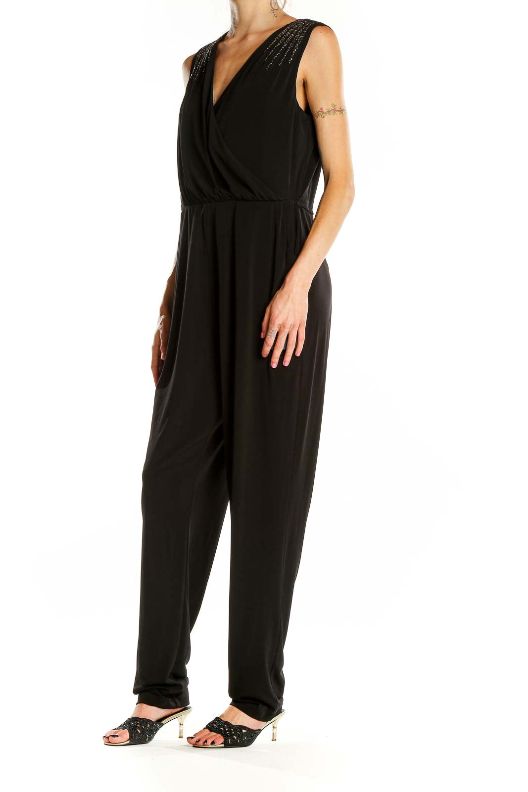 Front view of Calvin Klein black jumpsuit with V-neck and embellished shoulders