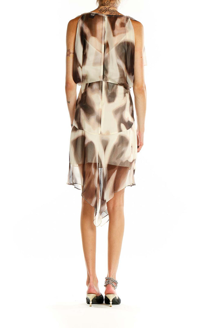 Back view of Moda International beige abstract print dress showing asymmetrical hemline