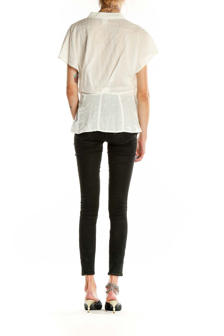 Back view of Akemi + Kin white wrap-style short sleeve blouse