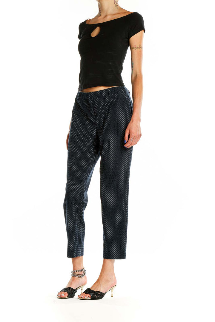 Side view of Chelsea28 navy polka dot cropped trousers on model with black top