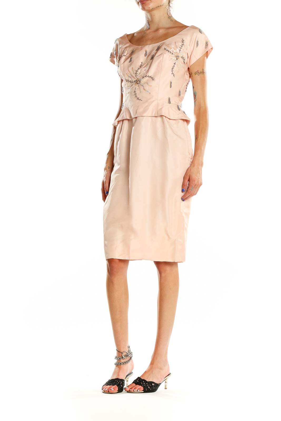 Front view of blush SilkRoll cocktail dress with silver embellishments and peplum design