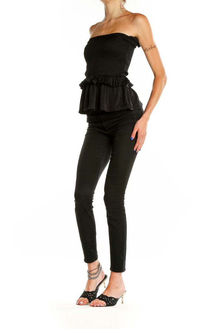 Front view of Olivaceous black strapless peplum top with smocked bodice