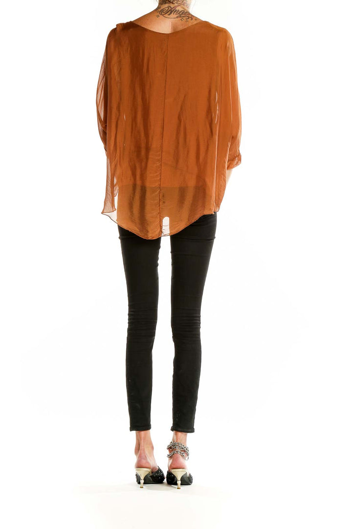 Back view of Gigi moda rust flowy layered blouse showing tiered hem design