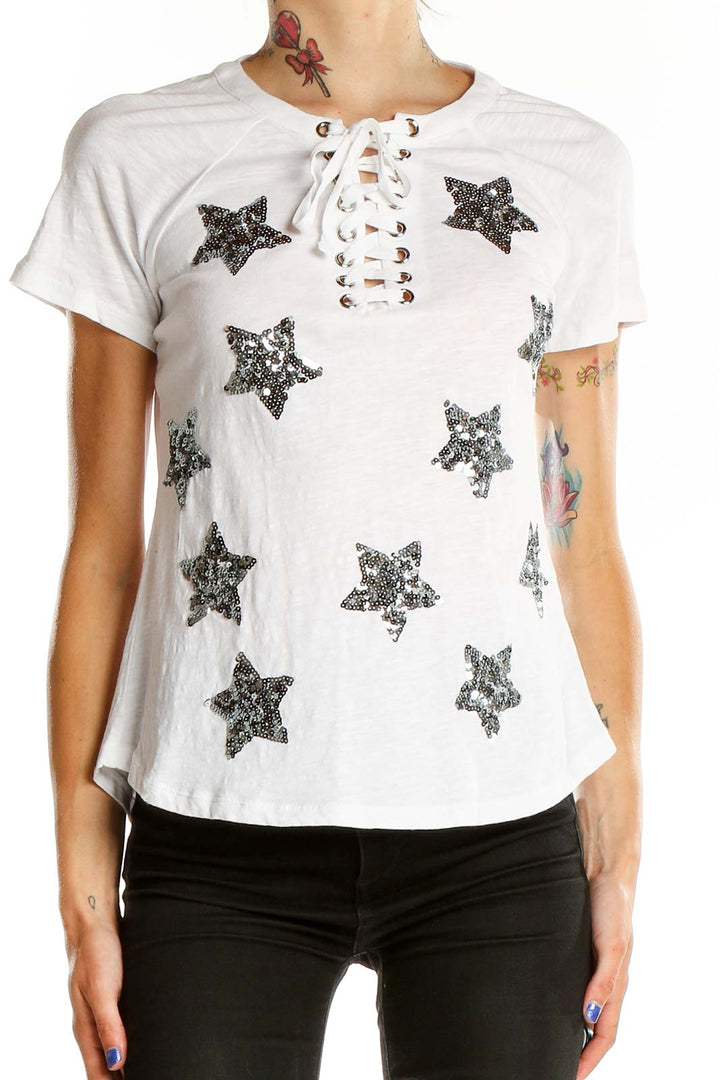 Front view of white INC t-shirt with sequin stars and lace-up neckline