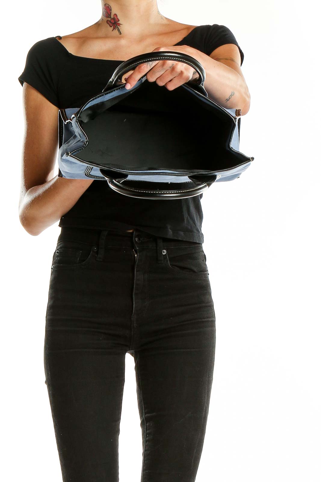 Open view of blue suede satchel showing spacious interior and black trim