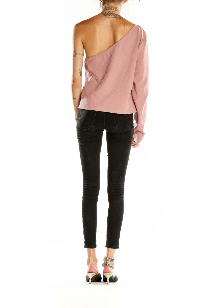 Back view of Anthropologie blush pink one-shoulder cropped top with black jeans