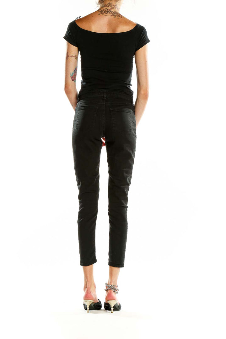 Back view of Acne black slim-fit cropped jeans on model