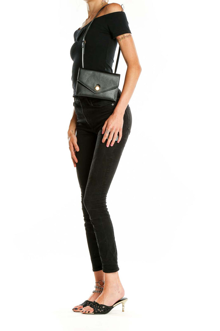 Front view of black Zara envelope crossbody bag with gold-tone button