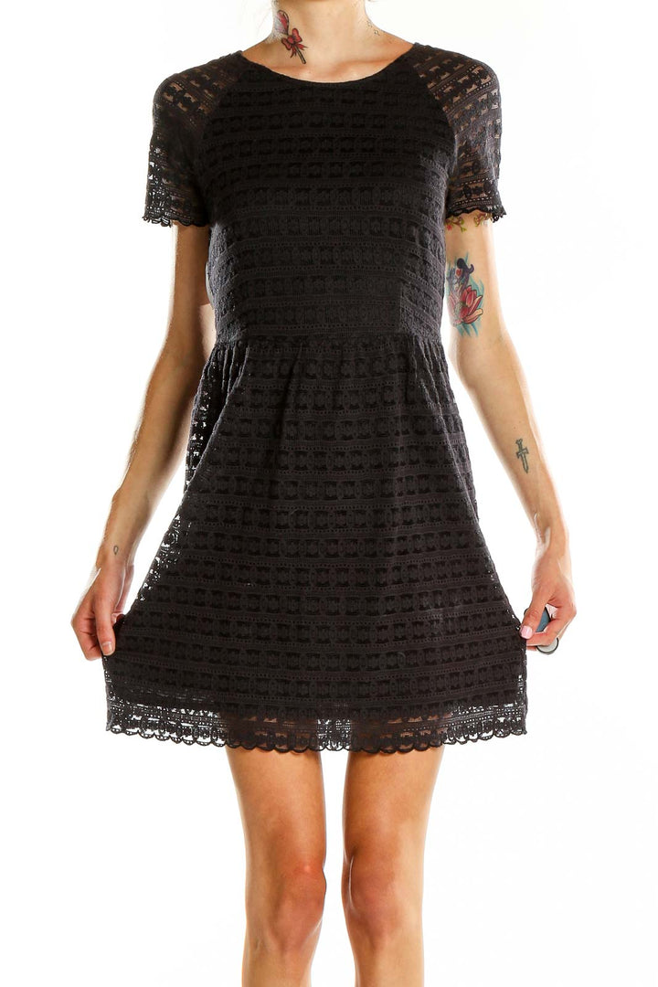 Front view of Free People black lace short-sleeve mini dress on model