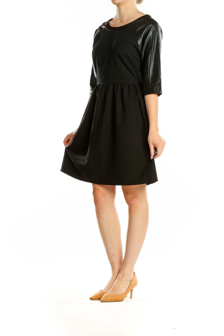 Front view of black fit and flare dress with faux leather sleeves by Romeo & Juliet Couture