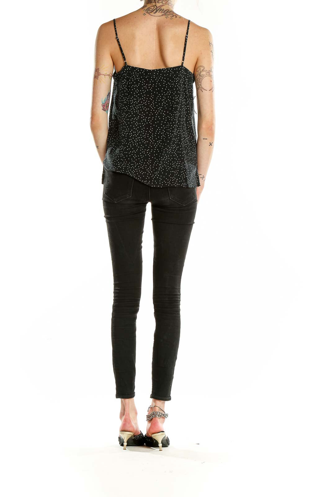 Back view of Madewell black silk camisole with white polka dots and model wearing black jeans