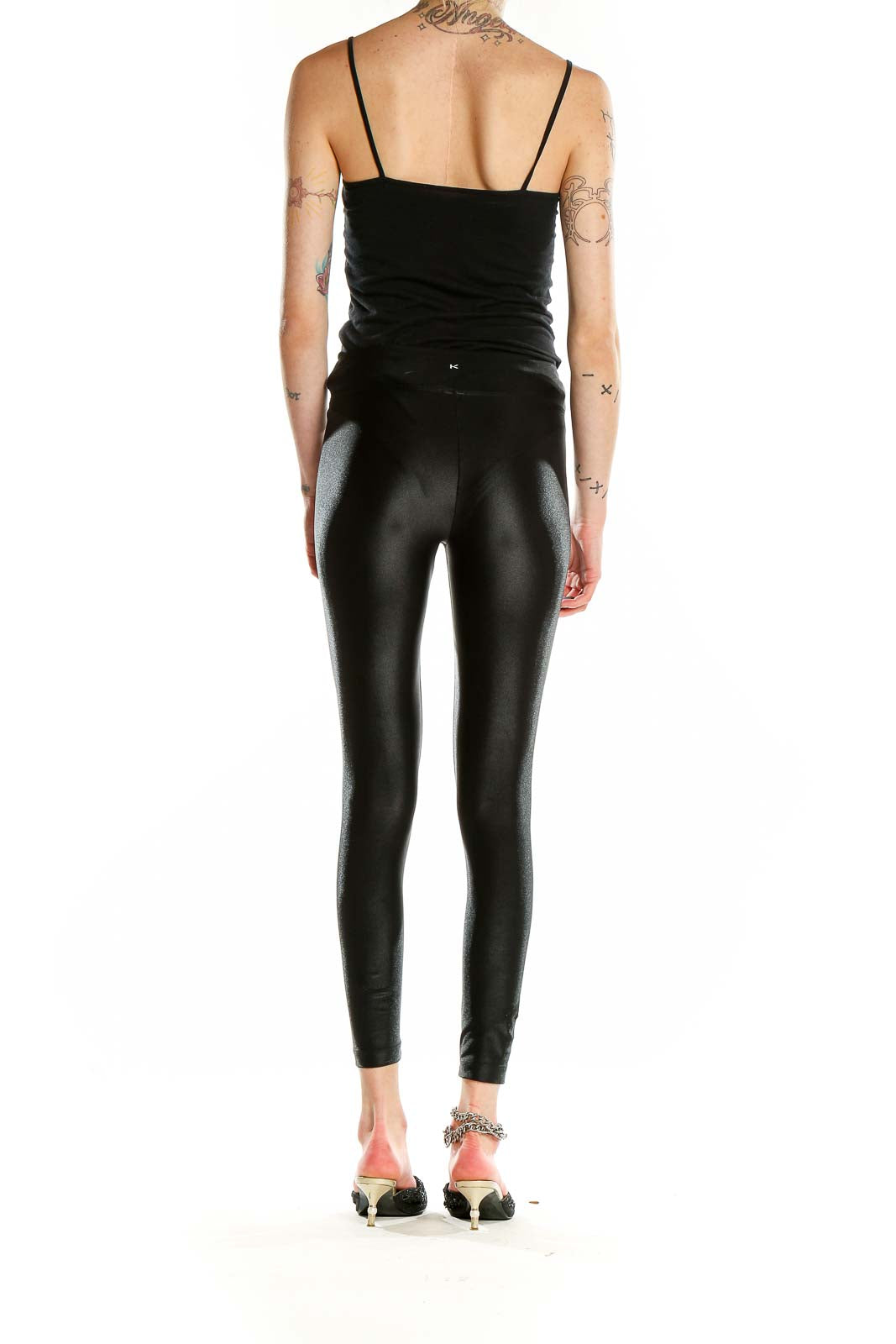 Back view of KORAL black shiny high-waisted leggings on model